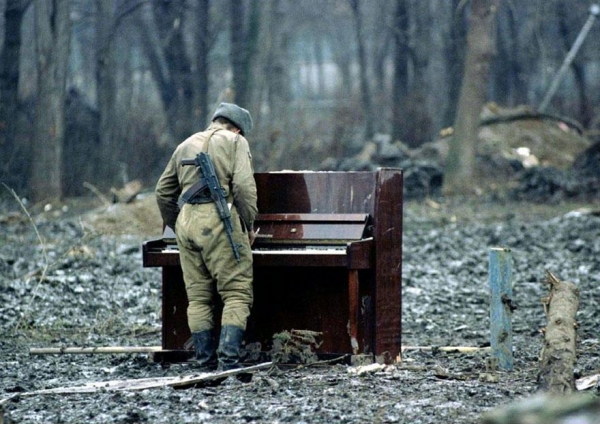 Rosyjski żołnierz gra na opuszczonym pianinie w Czeczenii