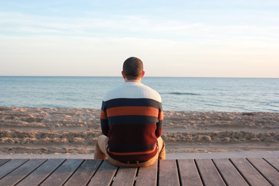 mężczyzna siedzący na plaży