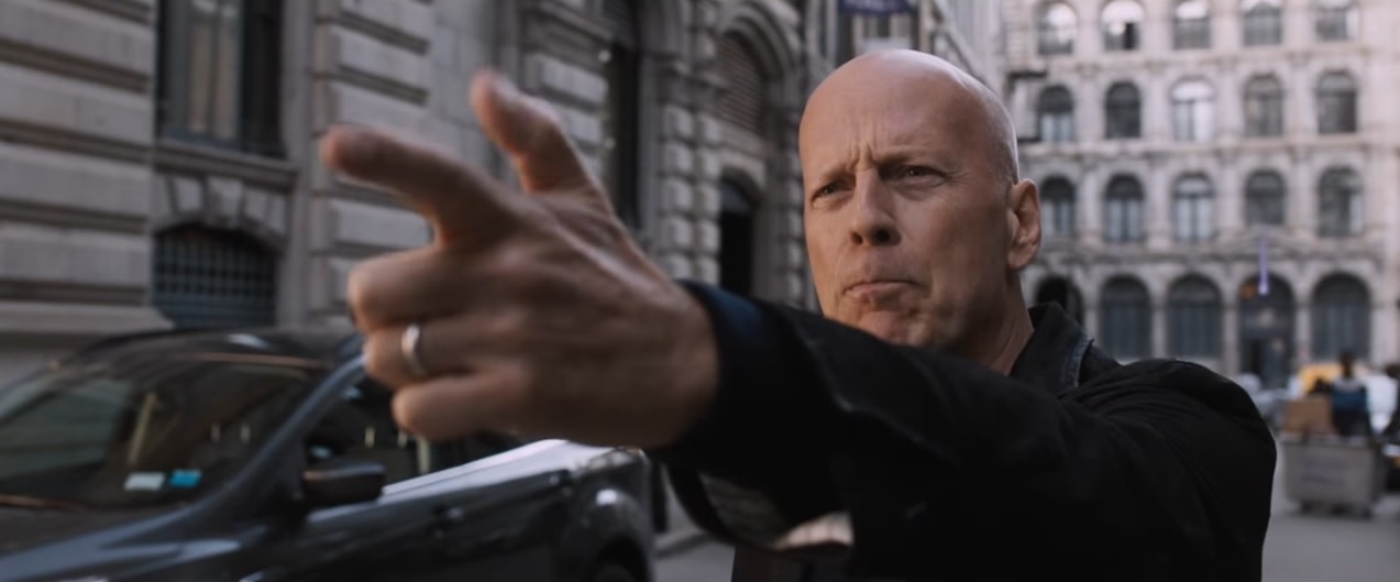 Bruce Willis mierzy do kogoś z ręki udającej pistolet