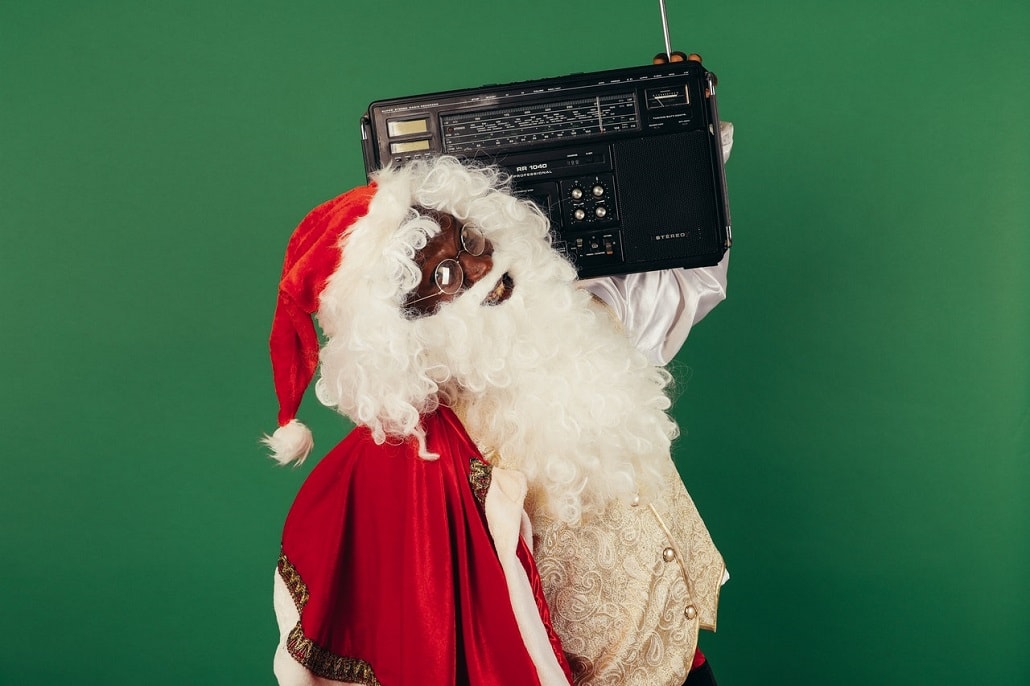 Święty Mikołaj z boomboxem na ramieniu, na zielonym tle.