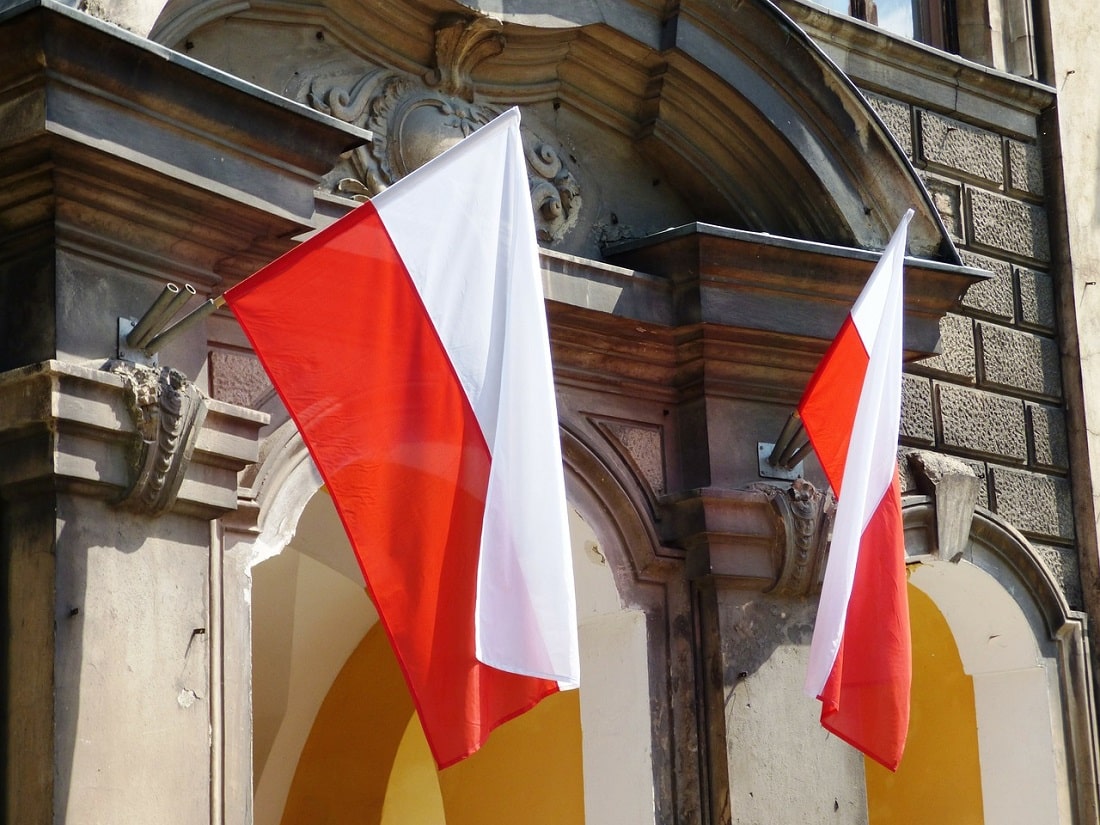 Polskie flagi przed starym budynkiem