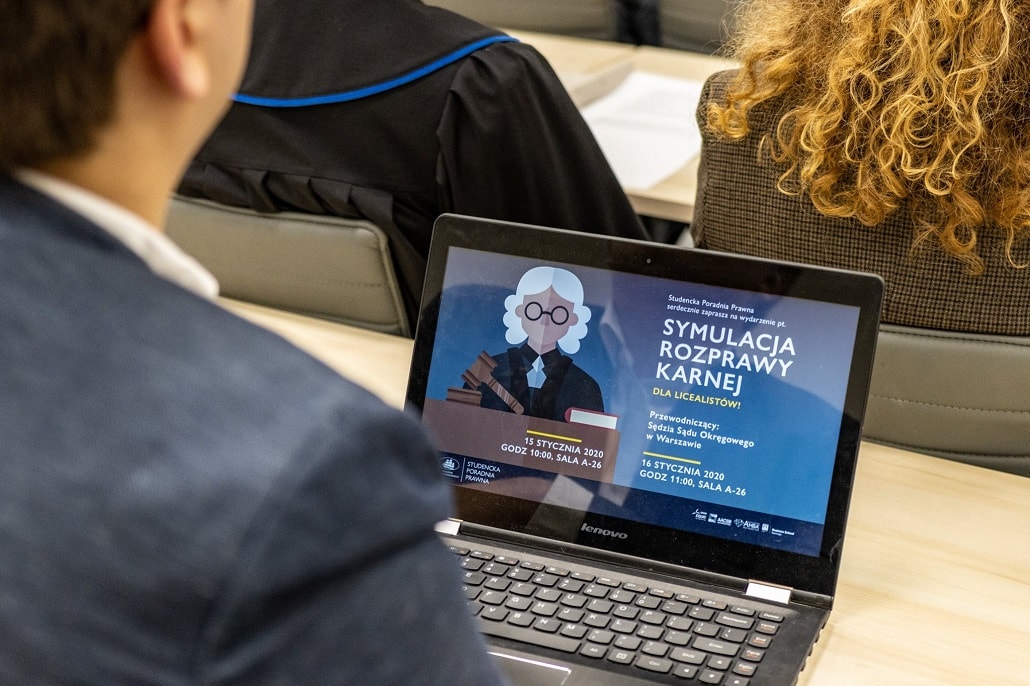 Student i laptop z plakatem symulacji rozpar sdowych w ALK
