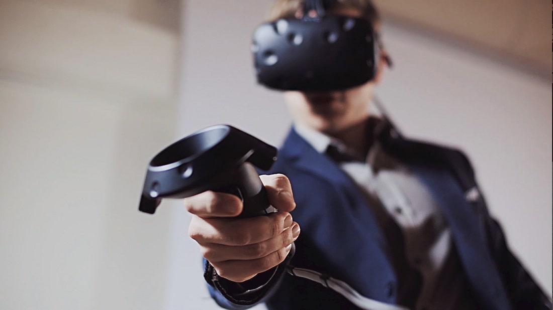 Człowiek w garniturze z założonymi goglami VR