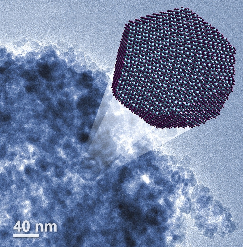 Trójwymiarowa wizualizacja nanocząstki korundu. W tle rzeczywiste zdjęcie mikroskopowe (kolory sztuczne)