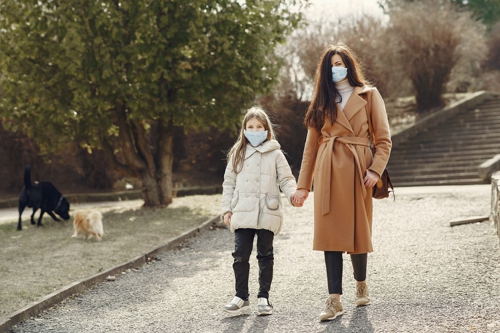 Kobieta i dziewczynka w maskach na spacerze